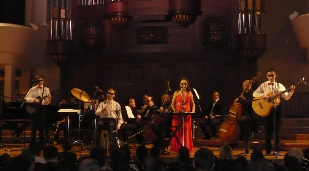 Members of the NeZaMi Ensemble perform on a stage.
