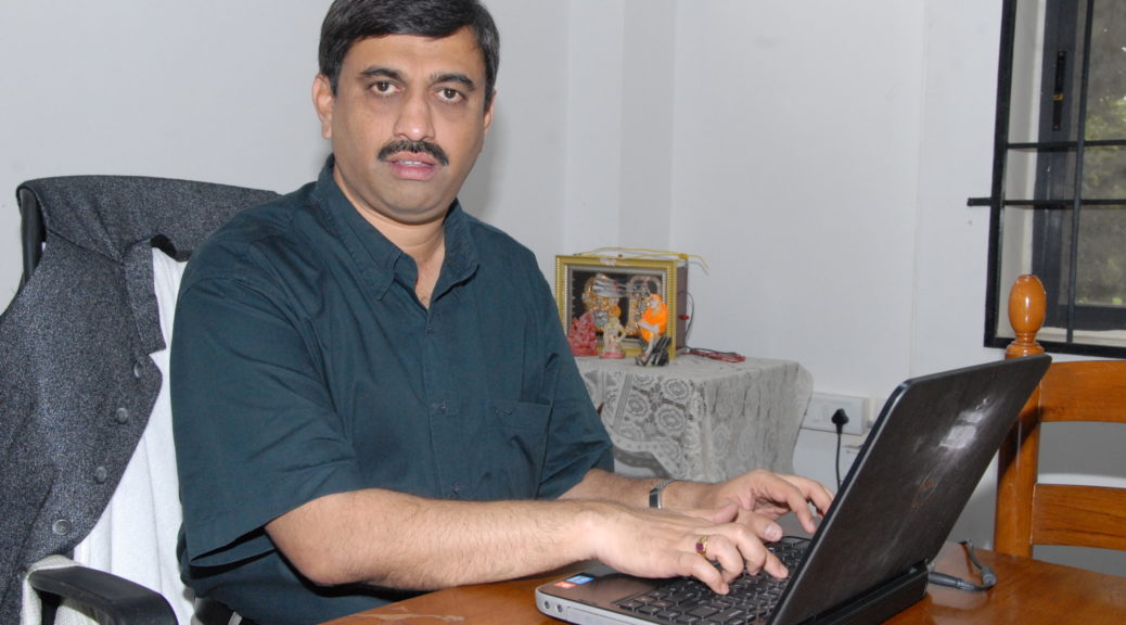 Mahantesh G.K. works at a table with his computer.